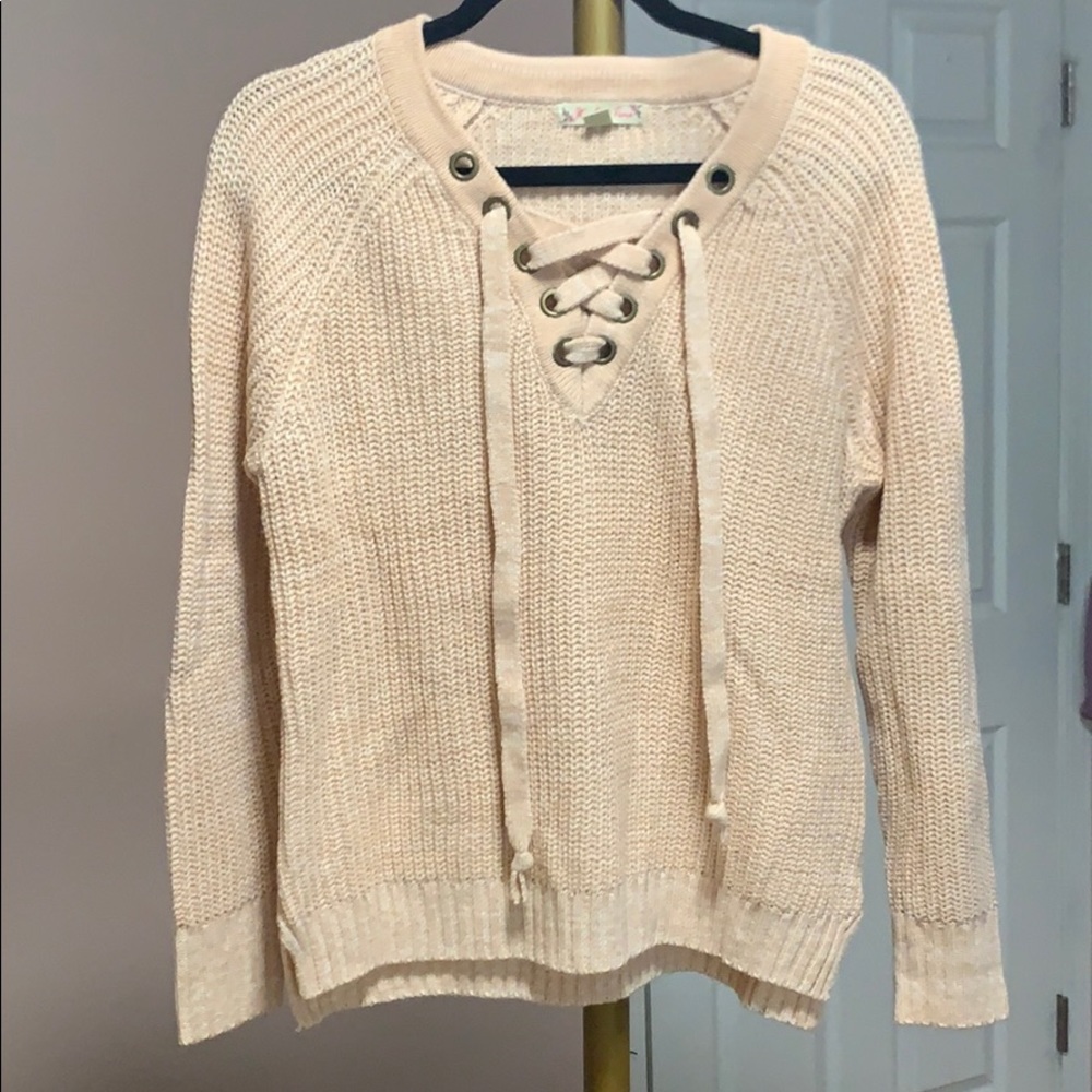 pink sweater with crisscross ties in the front.
